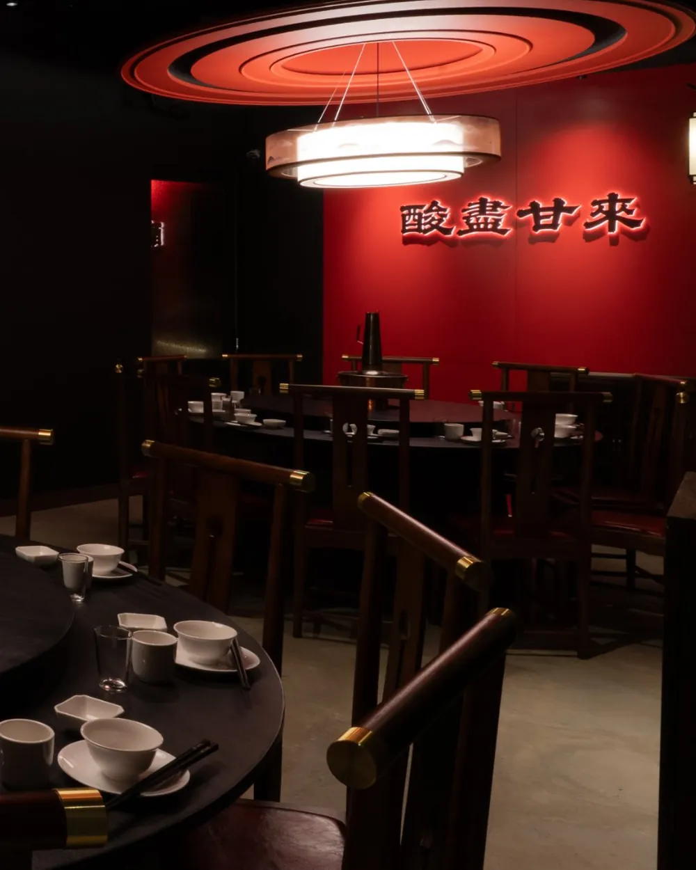 四平聚包廂:朱紅牆上掛著「酸盡甘來」,吊燈下官帽椅圍著圓桌